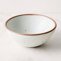 a white and brown bowl sitting on top of a table