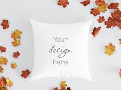 a white pillow with the words your design here surrounded by autumn leaves