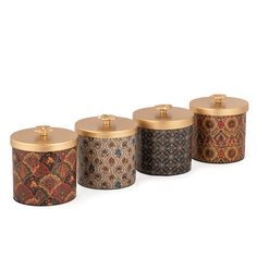 four canisters with gold lids and designs on them