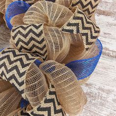 burlap wreath with blue and black chevrons on wooden background, top view