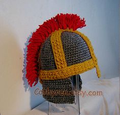 a crocheted helmet with red and yellow hair is on top of a table