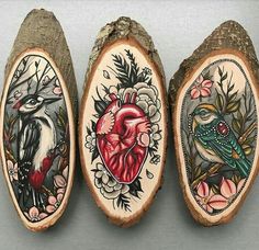 three pieces of wood with painted designs on them and one piece has a heart in the middle