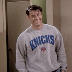 a man standing in front of a door wearing a sweater with the word knicks on it