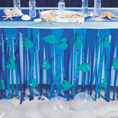 the table is set up with blue and white decorations for an under the sea party