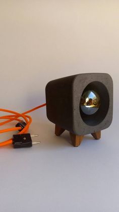 a small speaker with an orange cord connected to it