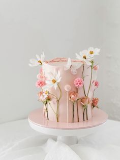 a pink cake with white flowers on top