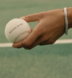 a person holding a tennis ball in their hand