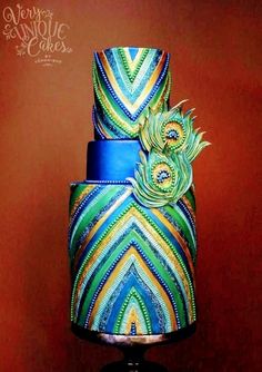 a three tiered cake decorated with peacock feathers