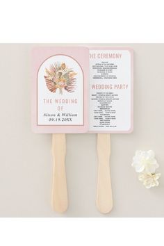 the wedding program fan is next to a flower