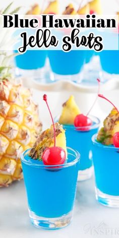 blue hawaiian jello shots with pineapples and cherries on the rim in small cups