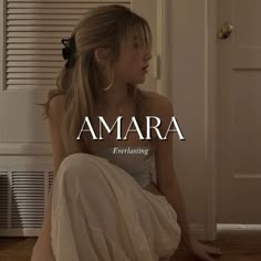 a woman sitting on the floor in front of a door with words that read amara everlasting