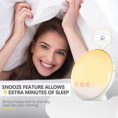 a woman laying in bed with the alarm clock on top of her head and smiling