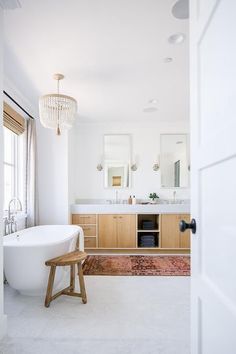 a bathroom with a large white tub next to a sink