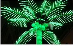 a palm tree is lit up with green lights