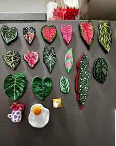 a refrigerator covered in magnets with different types of heart shaped decorations on the front