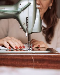 a woman using a sewing machine to sew something