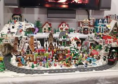 a christmas village is displayed in front of a television