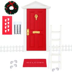 a red front door with welcome mat, wreath and white picketer fence surrounding it