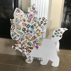 a white dog with lots of different stickers on it's back and side