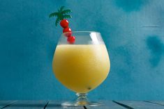 a glass filled with orange juice and garnished with a cherry on the top