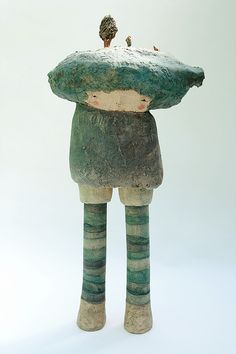 a ceramic figurine is holding a large rock