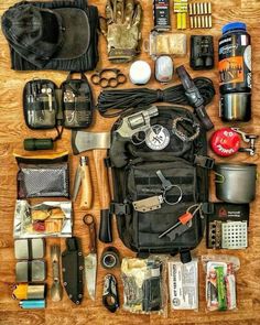 an assortment of items laid out on a wooden table including gloves, knifes, scissors and other things