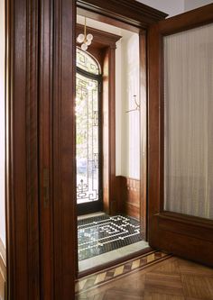 an open door with a chess board on the floor next to it and a window