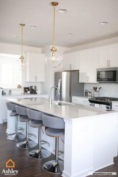 a kitchen with white cabinets and an island in the middle is surrounded by stools