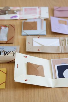 an open book sitting on top of a wooden table next to papers and envelopes