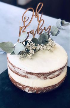 a cake that is sitting on top of a table with flowers and leaves around it