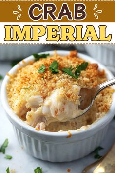 a close up of a spoon in a casserole dish with the words crab imperial on it