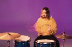 a man sitting on top of a drum set