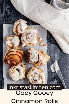 cinnamon rolls with icing sitting on top of a piece of paper