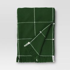 a green and white checkered blanket with fringes