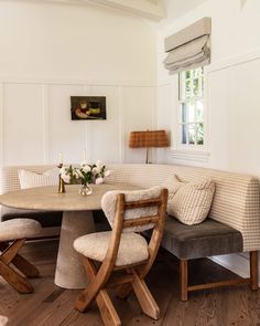 a table with two chairs around it and a couch in the corner next to it