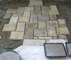 some bricks are laying on the ground next to a paver with cement in it