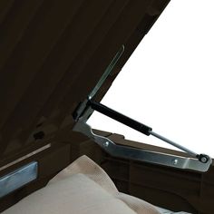 the inside of an open car trunk with a seat belt and handle on it's side