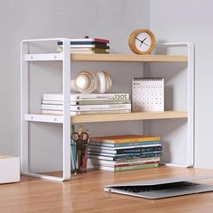 a laptop computer sitting on top of a wooden desk next to a shelf filled with books