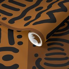 an animal print wallpaper with black and brown designs on the walls, including a round hole in the center