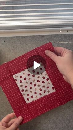 someone is making an origami house out of red fabric and white polka dots