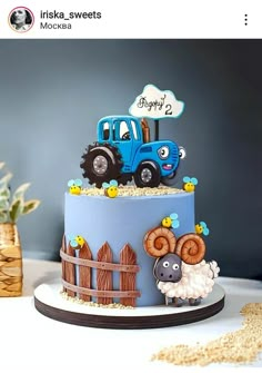 a birthday cake with a tractor and farm animals on the top is decorated in blue frosting