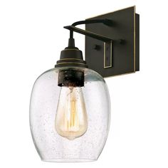 a light that is on the wall next to a glass lamp shade with a black metal arm