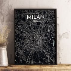 a black and white map of the city of milan, italy on a wooden shelf