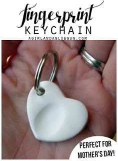 a hand holding a white heart shaped keychain with the words perfect for mother's day written on it