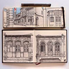 two notebooks with drawings of buildings on them