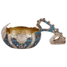 an ornately decorated metal bowl with two handles