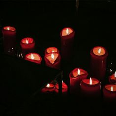 many red candles are lit in the dark