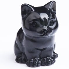 a black cat figurine sitting on the ground