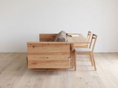 a wooden table with two chairs next to it and a fish in the drawer on top