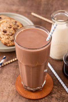 there is a chocolate milkshake and cookies on the table